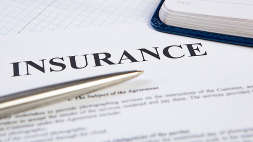 Paper with insurance typed at the top.  A silver pen lays over the paper.