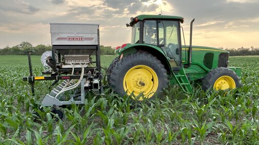 Tractor planting cover crops into corn.