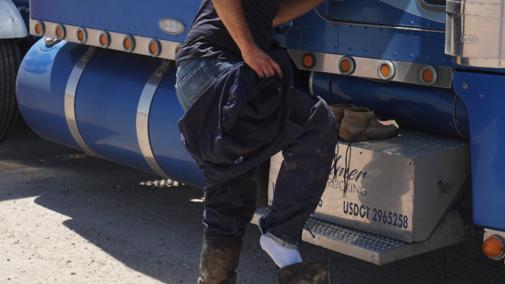 a truck driver putting on his boots
