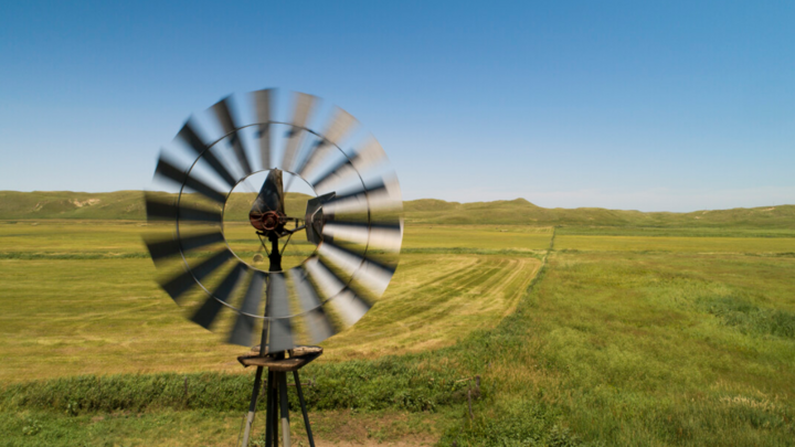 Windmill over mowed hay meadow