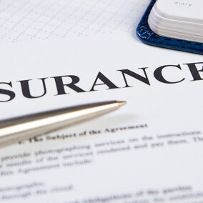 Paper with insurance typed at the top.  A silver pen lays over the paper.