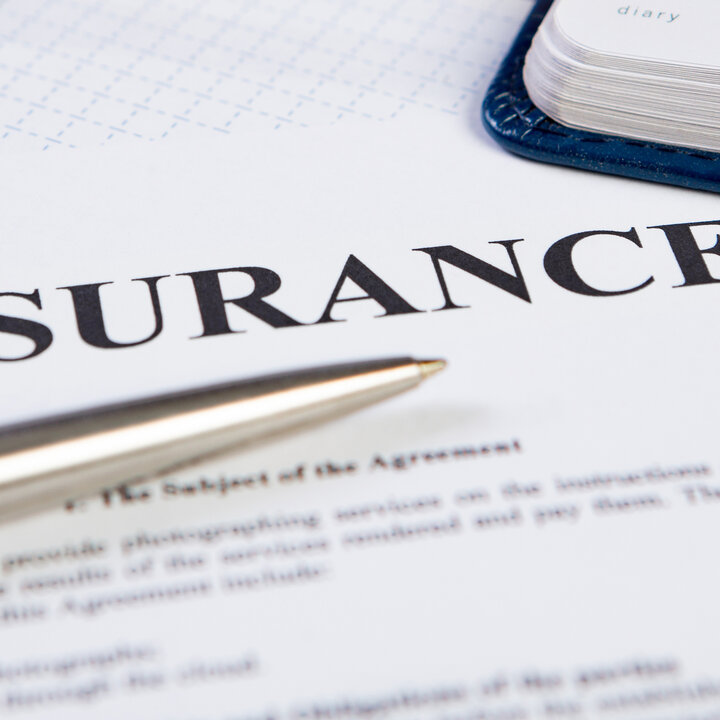 Paper with insurance typed at the top.  A silver pen lays over the paper.