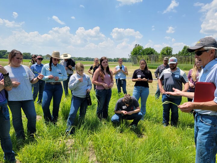 Students listening to teacher in pasture