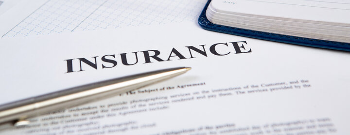 Paper with insurance typed at the top.  A silver pen lays over the paper.