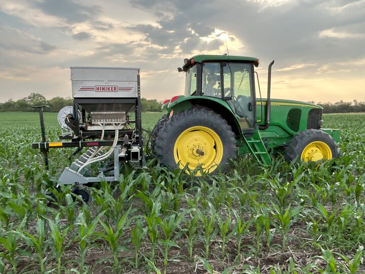 Tractor planting cover crops into corn.
